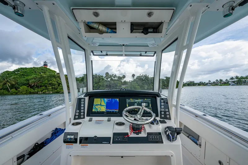 Slide: The Image of 2023 Robalo R302 Center Console boat interior with navigation screens and steering wheel. - 8