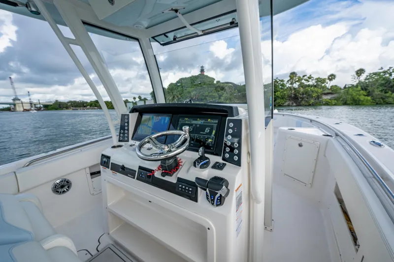 Slide: The Image of 2023 Robalo R302 Center Console boat interior with steering wheel and navigation screens. - 9
