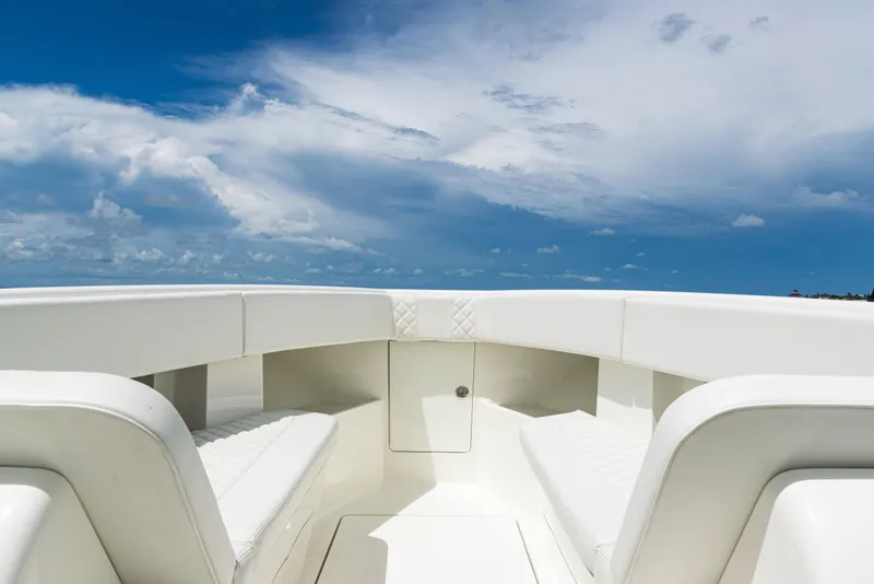 Slide: The Image of 2017 SeaVee 370z boat interior with white seating under a clear blue sky. - 11