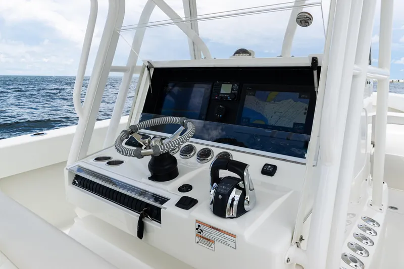 Slide: The Image of 2017 SeaVee 370z boat console with steering wheel and navigation screens on open water. - 24