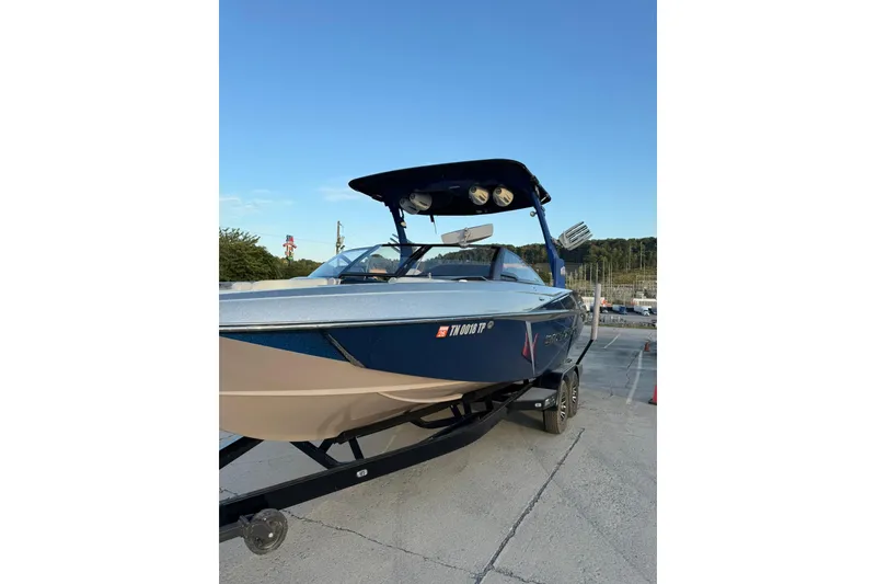 Slide: The Image of 2016 Malibu Wakesetter 25 LSV boat on trailer, parked outdoors under clear sky. - 1