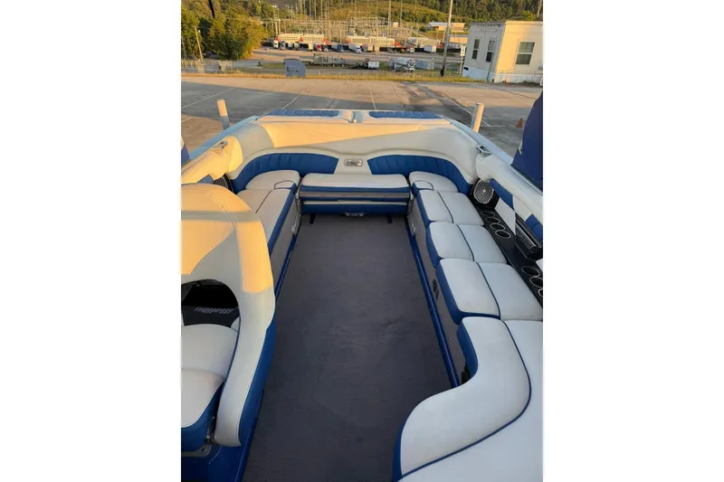Slide: The Image of 2016 Malibu Wakesetter 25 LSV interior with blue and white seating, docked outdoors. - 15