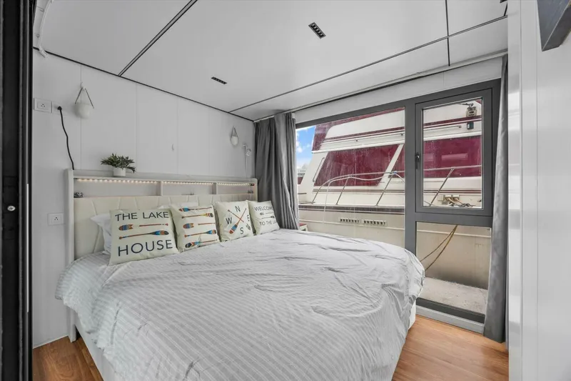 Slide: The Image of Modern bedroom interior on Gospel 39 houseboat, 2024 model, with nautical-themed decor and large window view. - 11