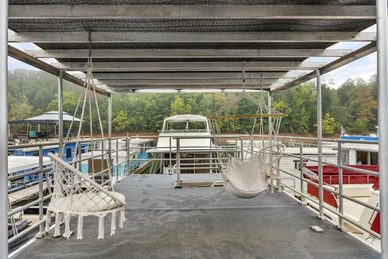 Slide: The Image of Rooftop deck of 2024 Gospel 39 houseboat with hanging chairs, overlooking marina and trees. - 16