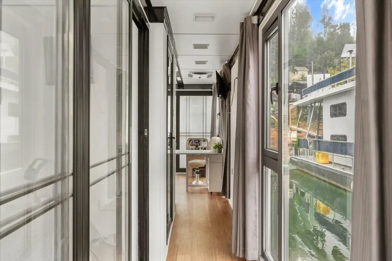 Slide: The Image of Modern houseboat interior with glass walls, wooden flooring, and scenic water views. Gospel 39, 2024 model. - 18