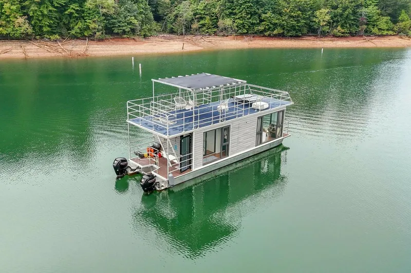 Slide: The Image of Houseboat Gospel 39, 2024 model, on serene lake with lush forest backdrop. - 23