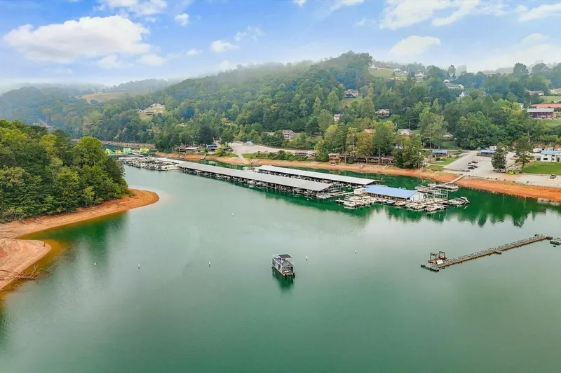 Slide: The Image of Aerial view of a serene lake with docks and lush green hills, Gospel 39, 2024. - 26