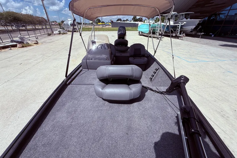 Slide: The Image of 2025 Bass Tracker Classic XL boat interior with gray seating and steering wheel. - 10