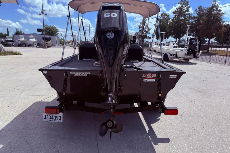Slide: The Image of 2025 Bass Tracker Classic XL boat with Mercury engine, parked under a canopy. - 6