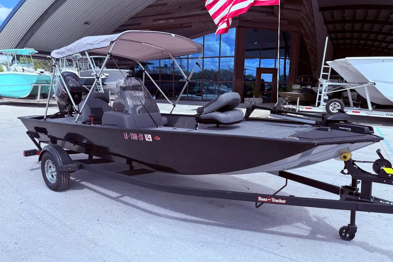 Slide: The Image of 2025 Bass Tracker Classic XL boat on trailer under blue sky. - 2