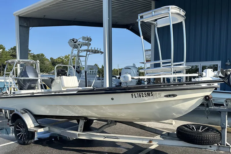 Slide: The Image of 2004 Hells Bay 18 Marquesa boat on trailer under a metal canopy. - 14