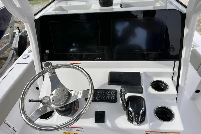 Slide: The Image of 2025 Sportsman Masters 247OE Bay Boat dashboard with steering wheel and dual displays. - 23