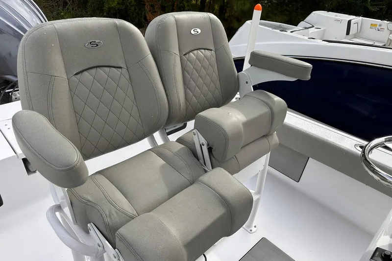 Slide: The Image of 2025 Sportsman Masters 247OE Bay Boat seats with gray upholstery and armrests. - 25