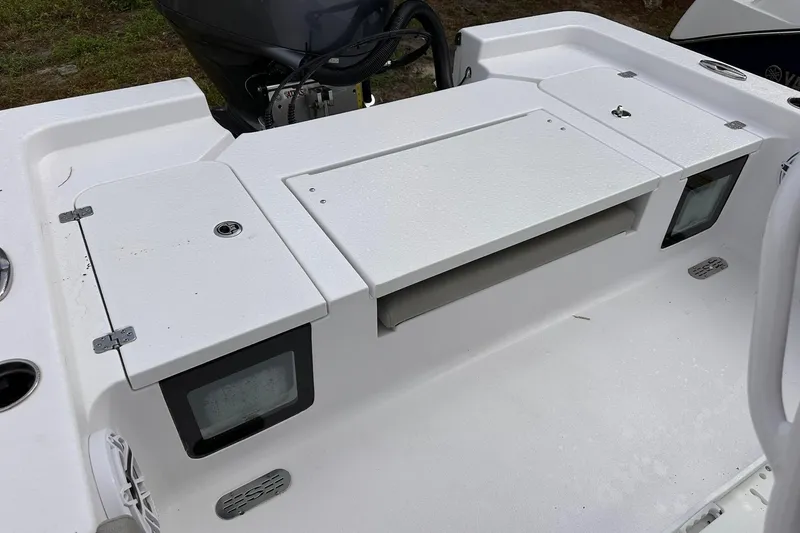 Slide: The Image of 2025 Sportsman Masters 247OE Bay Boat deck with storage compartments and engine view. - 26