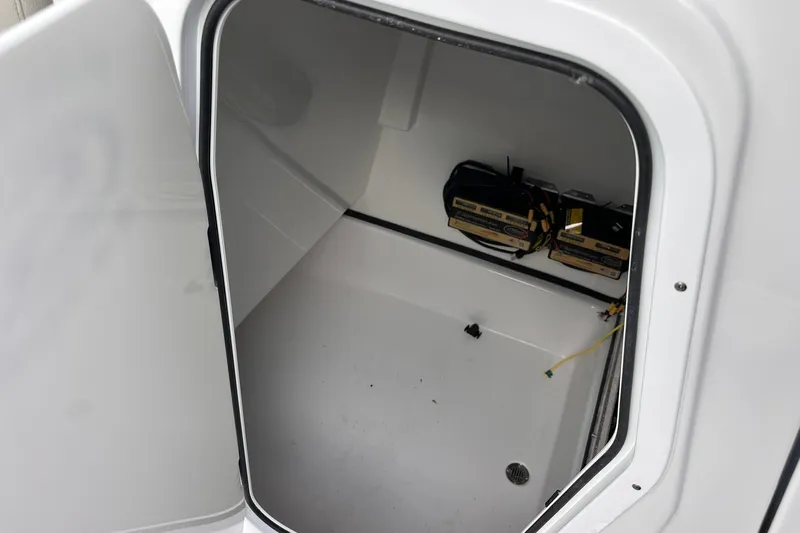 Slide: The Image of 2025 Sportsman Masters 247OE Bay Boat storage compartment with batteries visible inside. - 29