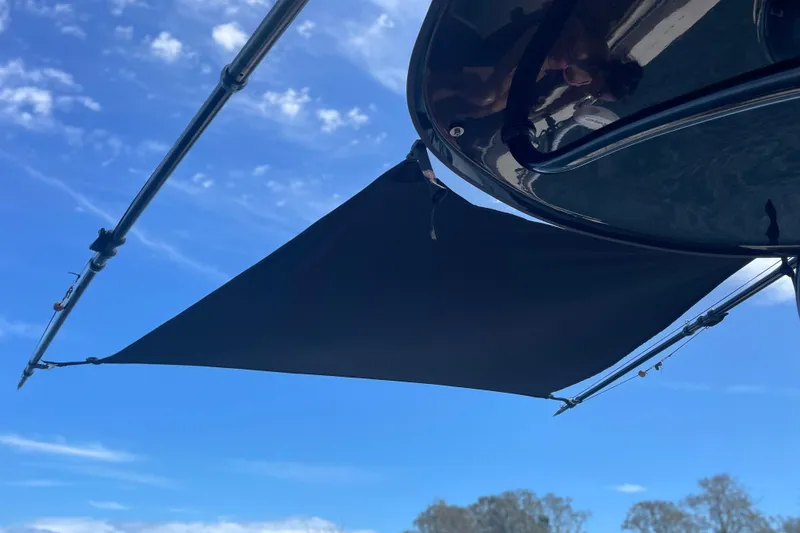 Slide: The Image of 2022 Pioneer 222 Islander boat with sunshade against blue sky. - 11