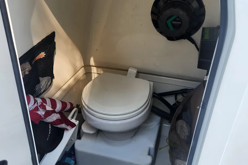 Slide: The Image of 2022 Pioneer 222 Islander boat interior with toilet and storage compartments. - 22