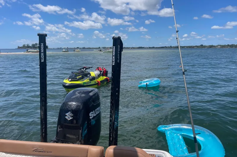 Slide: The Image of 2022 Pioneer 222 Islander boat on water with jet ski and inflatables nearby. - 7