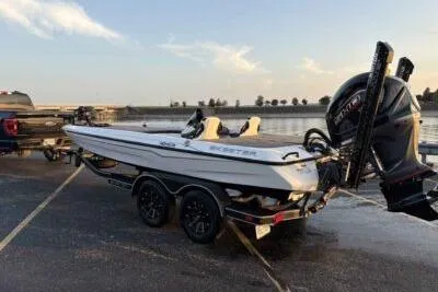 Slide: The Image of 2026 Skeeter ZXE20 boat on trailer by waterfront at sunset. - 2