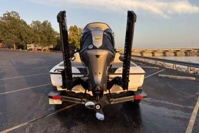 Slide: The Image of 2026 Skeeter ZXE20 boat parked near a scenic waterfront with trees and a bridge. - 3