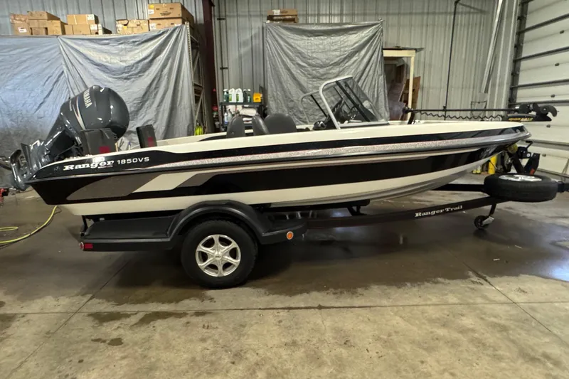 Slide: The Image of 2008 Ranger 1850 Reata boat in a garage, featuring a Yamaha motor and trailer. - 0