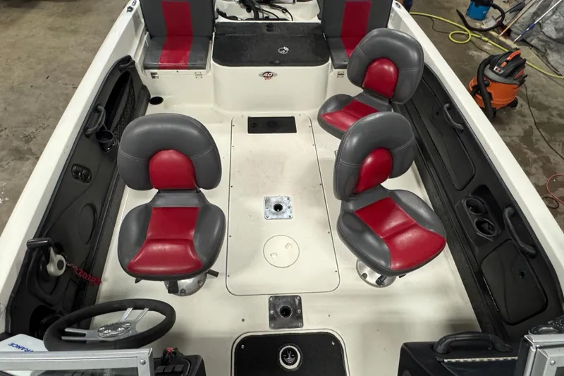Slide: The Image of 2008 Ranger 1850 Reata boat interior with red and gray seating, steering wheel, and storage compartments. - 14