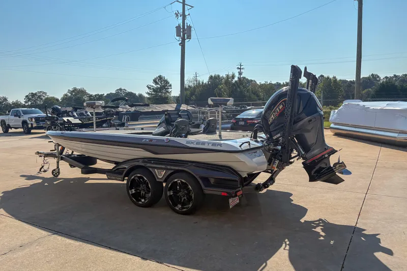 Slide: The Image of 2022 Skeeter FXR20 boat with powerful outboard motor in a sunny parking lot. - 5