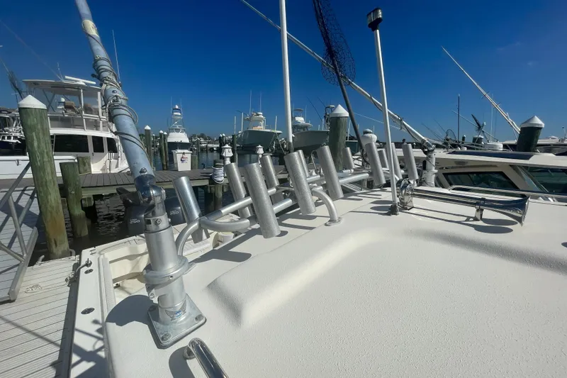 Slide: The Image of 2007 Parker 2820 XLD Sport Cabin boat docked at marina with fishing rod holders. - 100