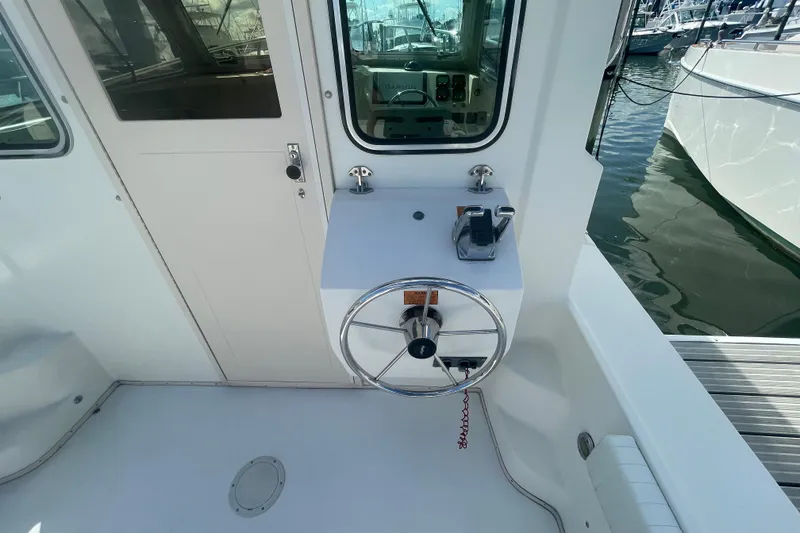 Slide: The Image of 2007 Parker 2820 XLD Sport Cabin helm with steering wheel and controls, docked at marina. - 11