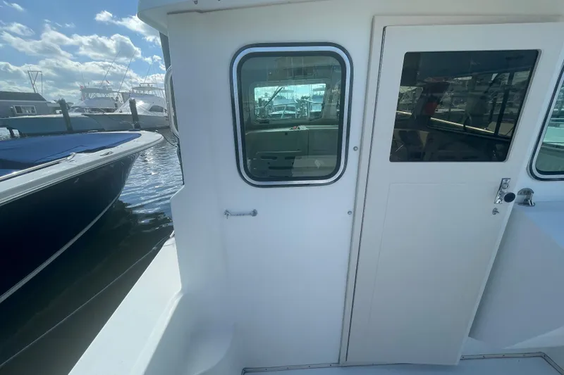 Slide: The Image of 2007 Parker 2820 XLD Sport Cabin boat docked, showing cabin door and window. - 12