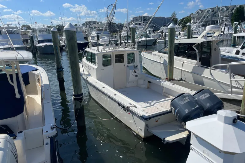 Slide: The Image of 2007 Parker 2820 XLD Sport Cabin boat docked in a marina under clear skies. - 2