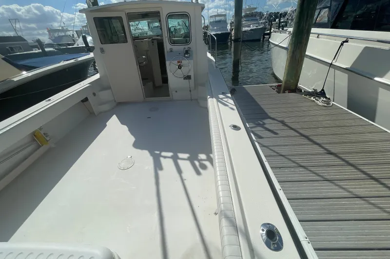 Slide: The Image of 2007 Parker 2820 XLD Sport Cabin boat docked, showcasing spacious deck and cabin entrance. - 33