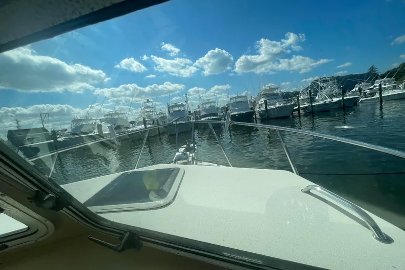 Slide: The Image of 2007 Parker 2820 XLD Sport Cabin boat docked, surrounded by other boats under a blue sky. - 63