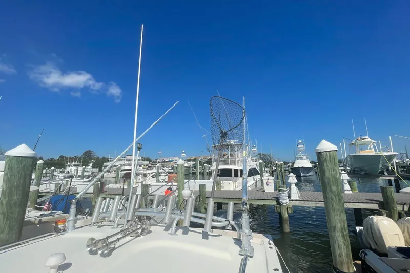 Slide: The Image of Boats docked at a marina under a clear blue sky, featuring a 2007 Parker 2820 XLD Sport Cabin. - 83