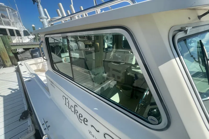 Slide: The Image of 2007 Parker 2820 XLD Sport Cabin boat docked, showcasing cabin windows and sleek design. - 99