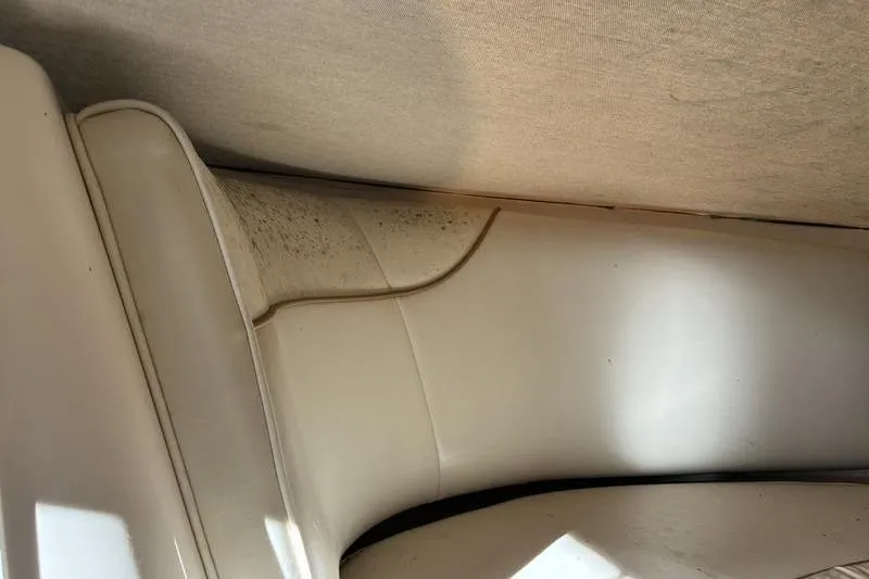 Slide: The Image of Interior of a 1999 Ebbtide 2300 boat showing white upholstery with slight discoloration. - 16