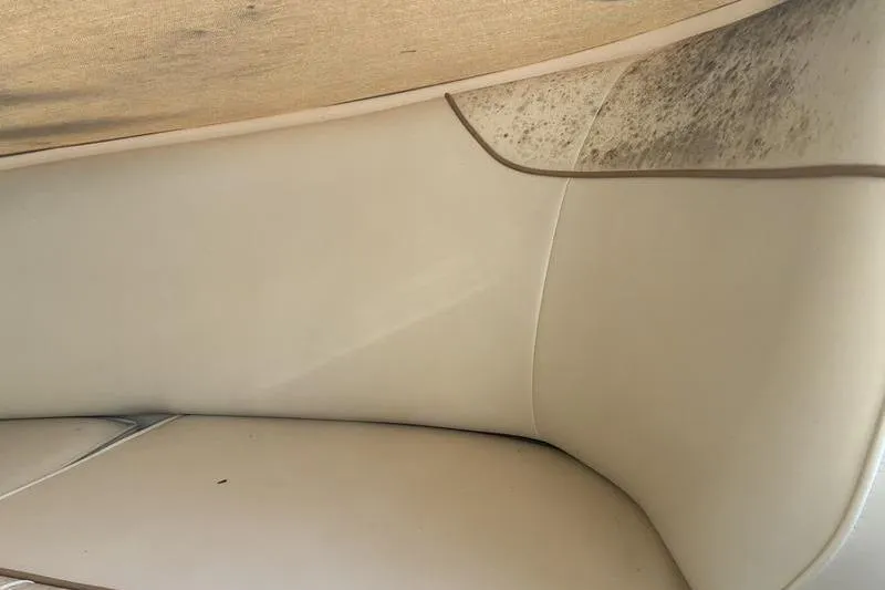 Slide: The Image of 1999 Ebbtide 2300 boat interior with beige upholstery and visible mold. - 19