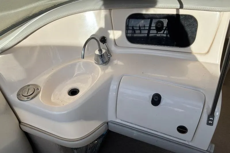 Slide: The Image of 1999 Ebbtide 2300 boat interior with sink and storage compartment. - 22