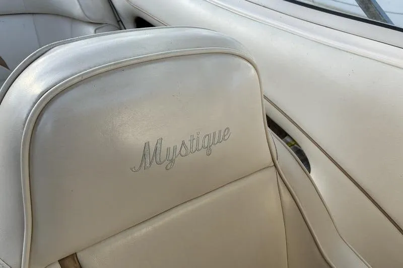 Slide: The Image of Cream leather seat with "Mystique" embroidery in a 1999 Ebbtide 2300 boat interior. - 23