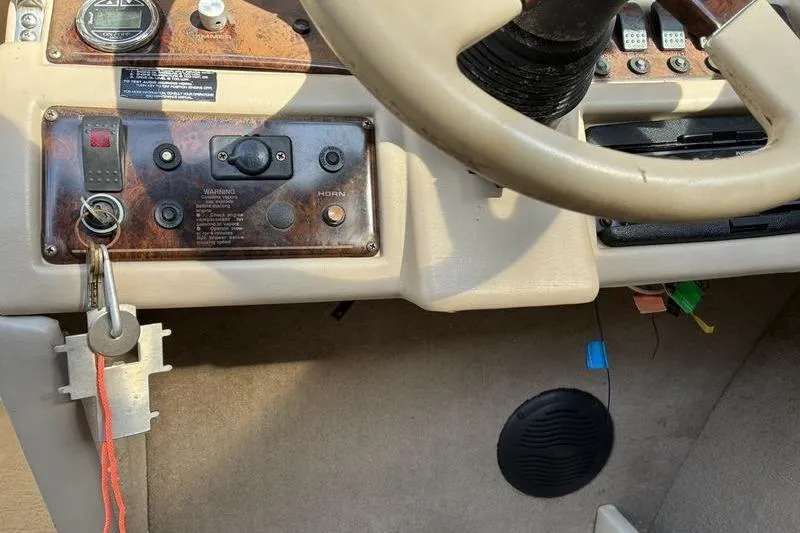 Slide: The Image of 1999 Ebbtide 2300 boat dashboard with steering wheel and control panel. - 28