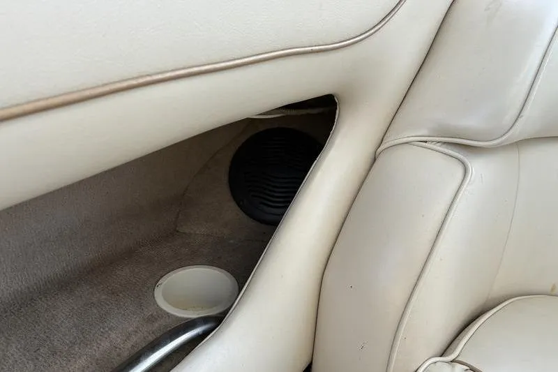 Slide: The Image of 1999 Ebbtide 2300 boat interior with beige upholstery and speaker detail. - 33