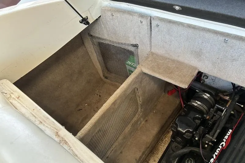 Slide: The Image of Interior view of a 1999 Ebbtide 2300 boat engine compartment with storage area. - 35