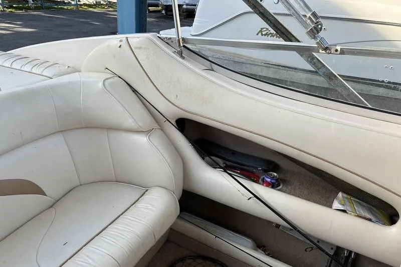 Slide: The Image of 1999 Ebbtide 2300 boat interior with white seating and fishing gear. - 38
