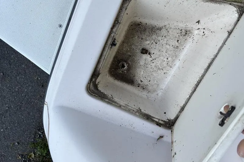 Slide: The Image of Dirty compartment on a 1999 Ebbtide 2300 boat, showing wear and debris. - 40