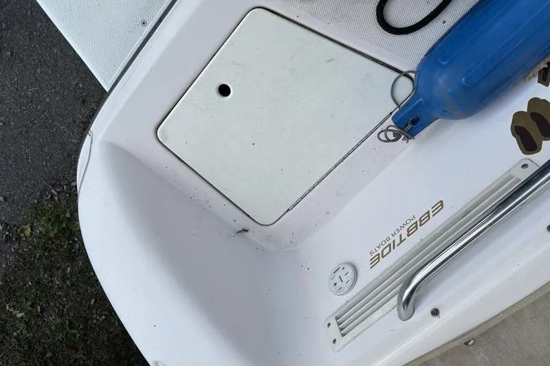 Slide: The Image of 1999 Ebbtide 2300 boat deck with blue fender and storage compartment. - 41