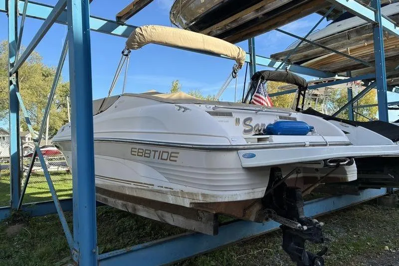 Slide: The Image of 1999 Ebbtide 2300 boat stored on metal rack, American flag visible. - 6