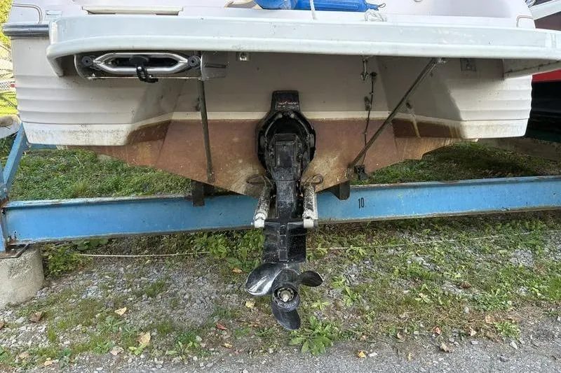Slide: The Image of Rear view of a 1999 Ebbtide 2300 boat on a trailer, showing the propeller and stern. - 7