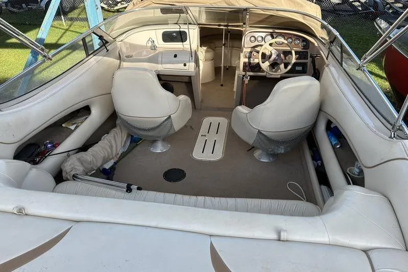 Slide: The Image of 1999 Ebbtide 2300 boat interior with white seating and steering console. - 8