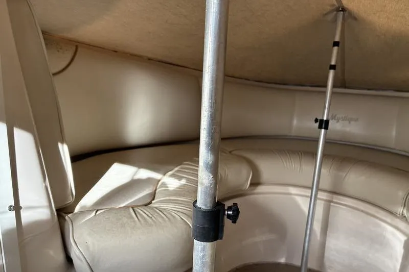 Slide: The Image of Interior of a 1999 Ebbtide 2300 boat with cushioned seating and support poles. - 17