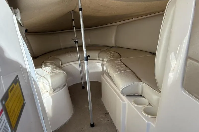 Slide: The Image of Interior of a 1999 Ebbtide 2300 boat with cushioned seating and cup holders. - 20